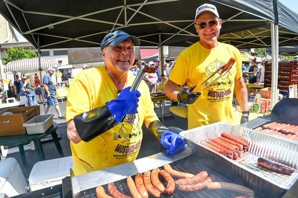 Two men grilling hot dogs at National Mustard Day in Middleton, 2023.