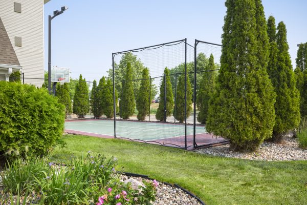 A tennis court in a backyard.